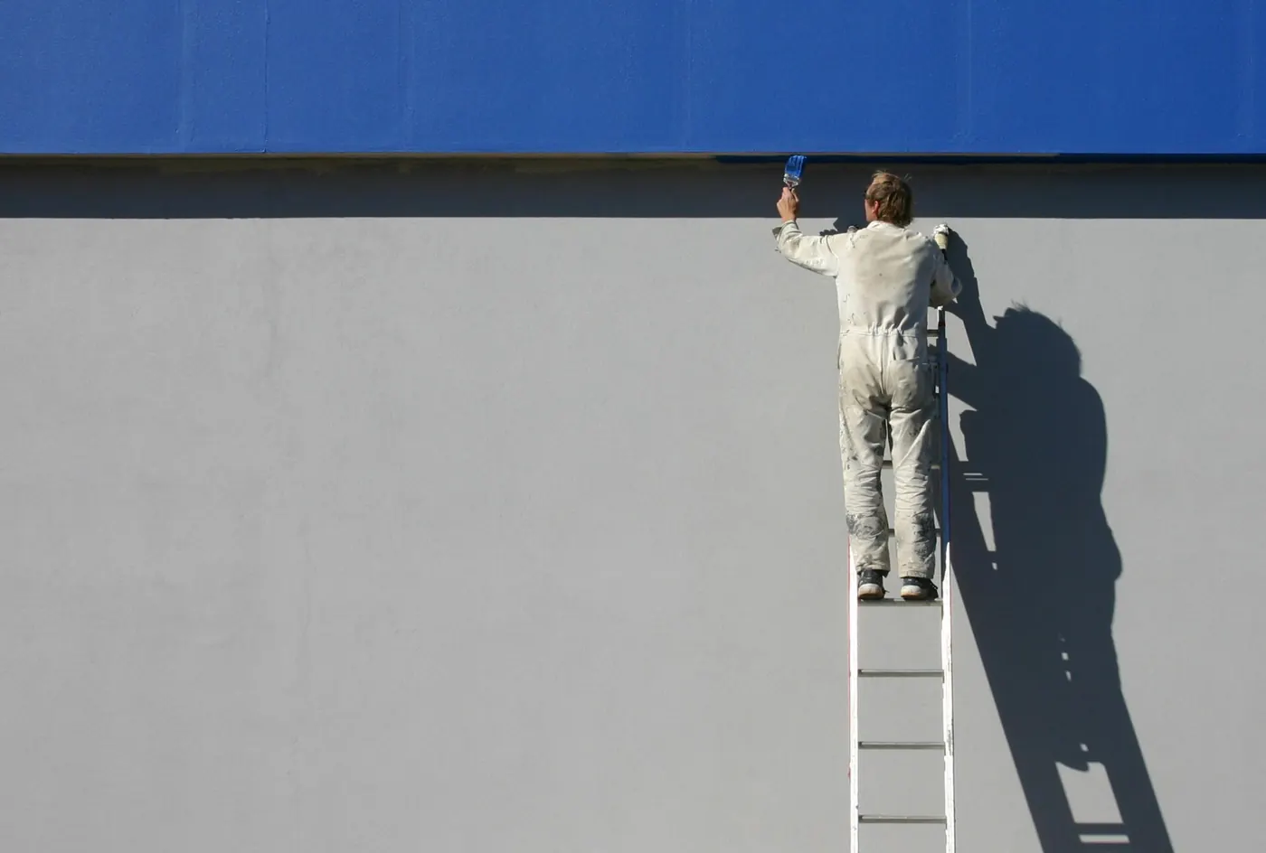 Exterior House Painting in Cumberland, RI — photo 3 — Cutting in the upper trim from the ladder